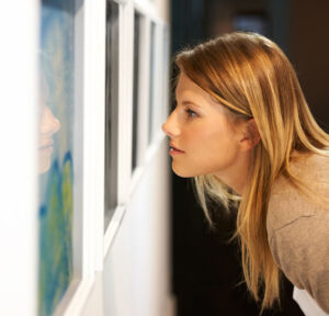 Woman looking closely at art featured 300x288